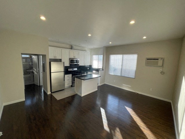 an empty kitchen with a refrigerator and a sink