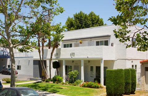 a white house with a lawn and trees in front of it