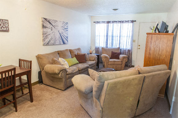 a living room with couches and chairs and a dining room table