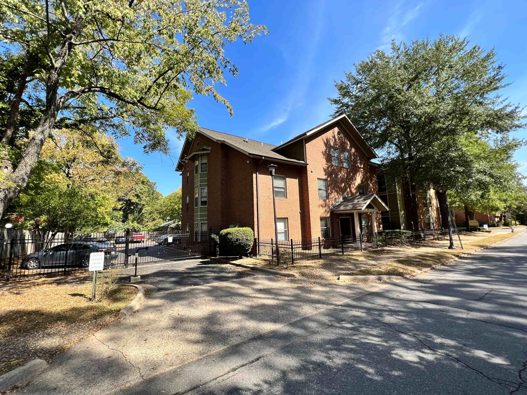 a red brick church with a fence and trees