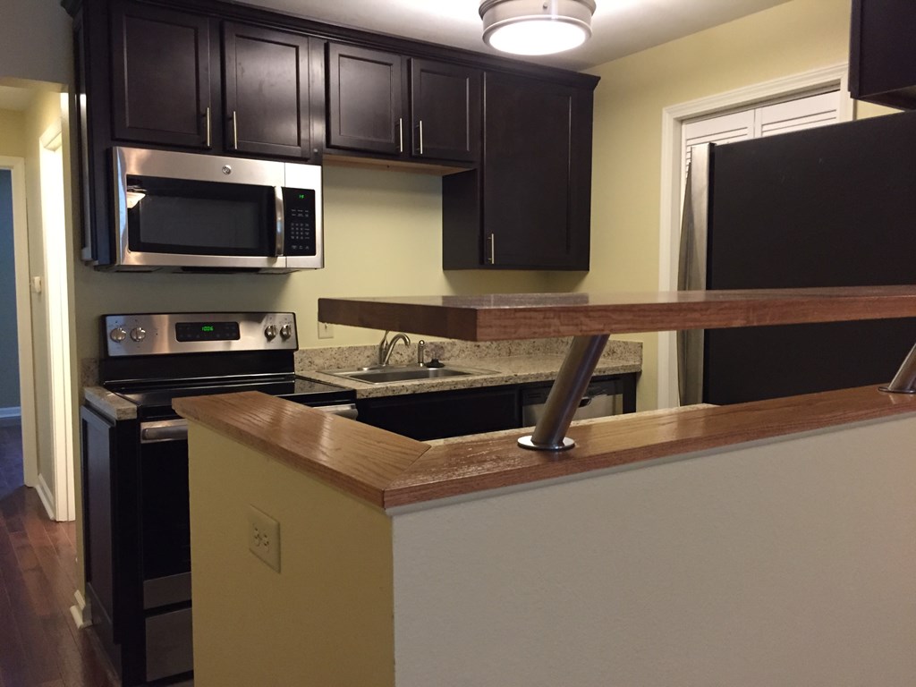 a kitchen with black appliances and a wooden counter top