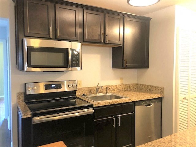 a kitchen with a stove and a sink and a microwave