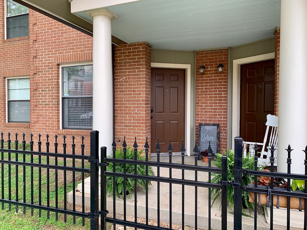 a house with a brown door and a black fence