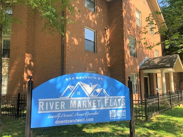 a river market flats sign in front of a brick building
