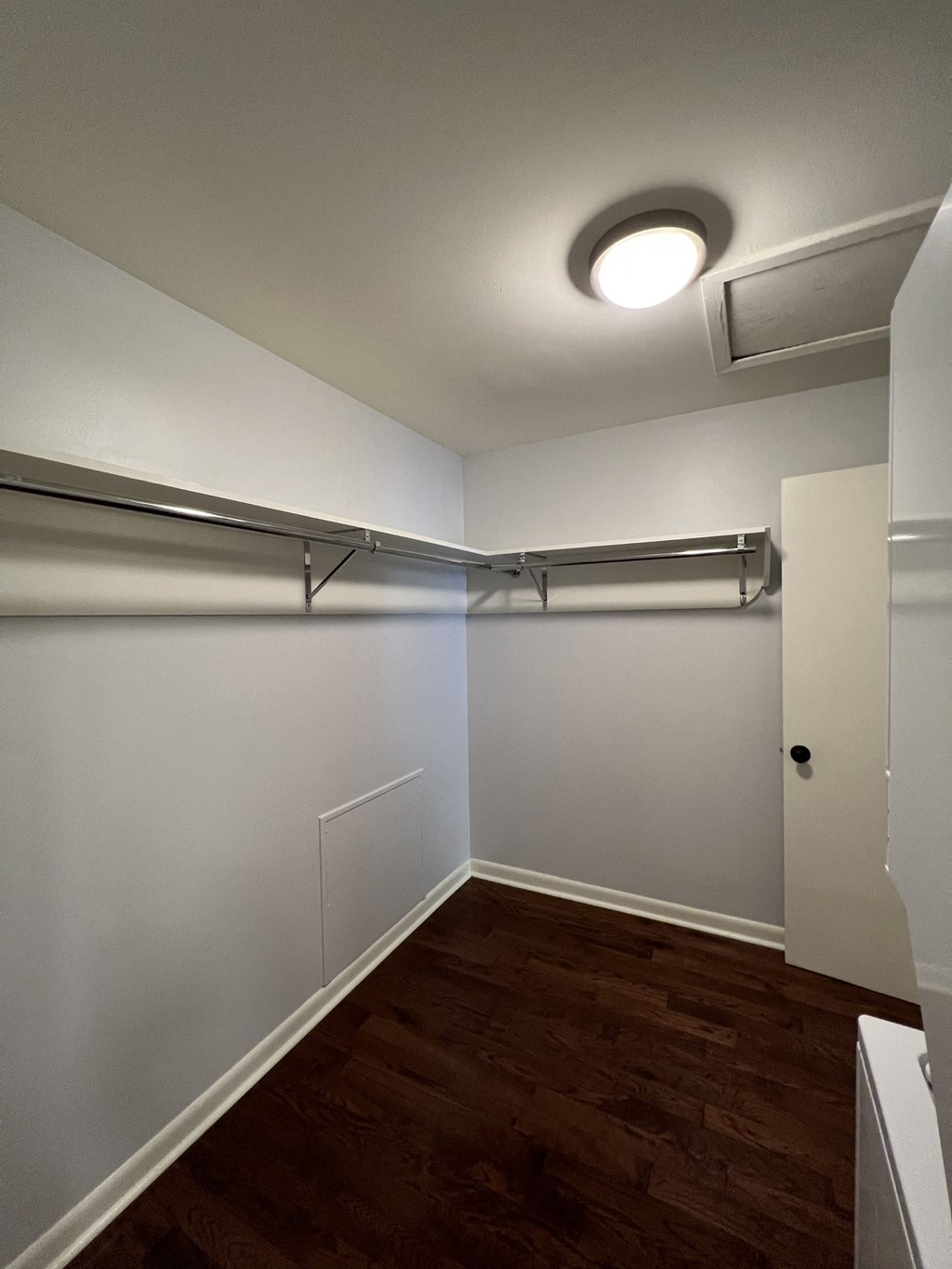 an empty room with white walls and a wood floor