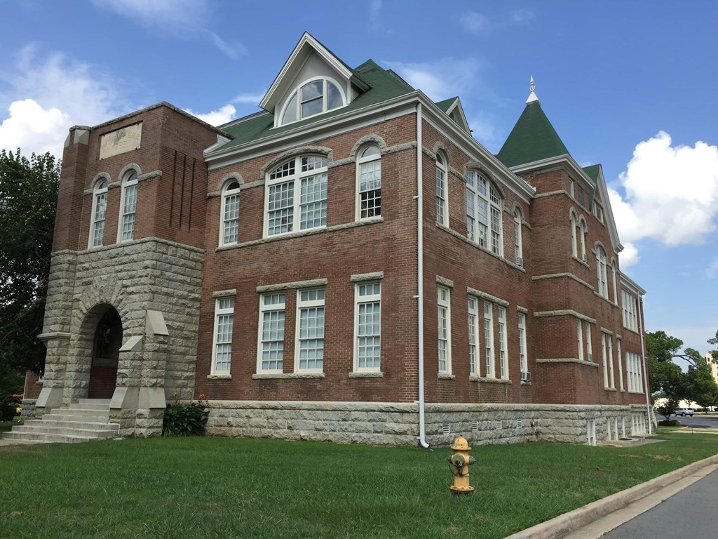 the front of a brick building with a yellow fire hydrant