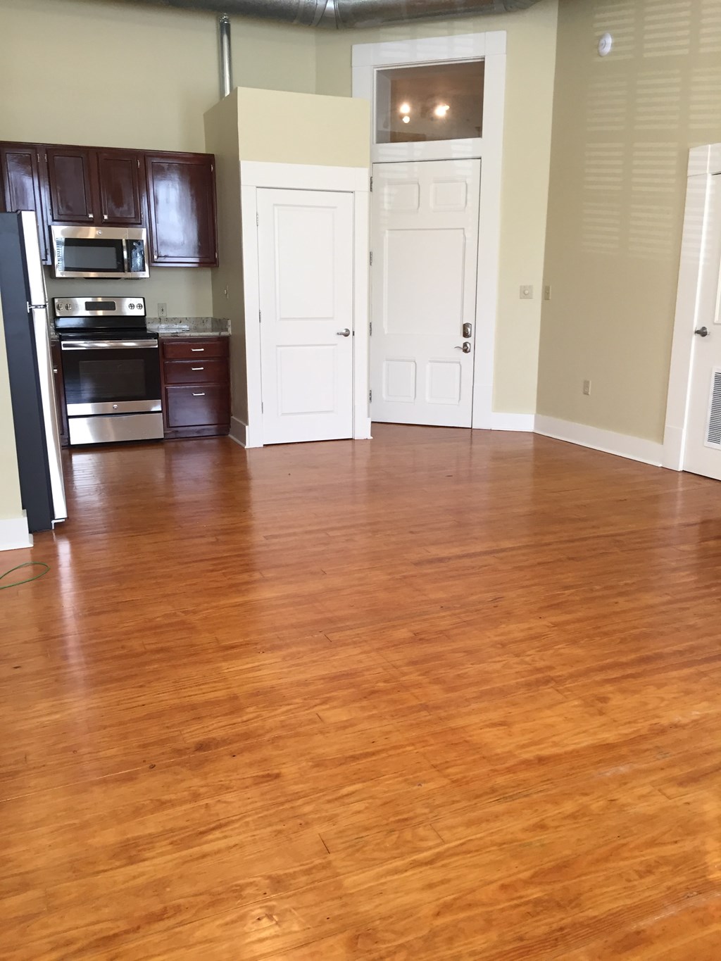 an empty kitchen and living room with wood floors