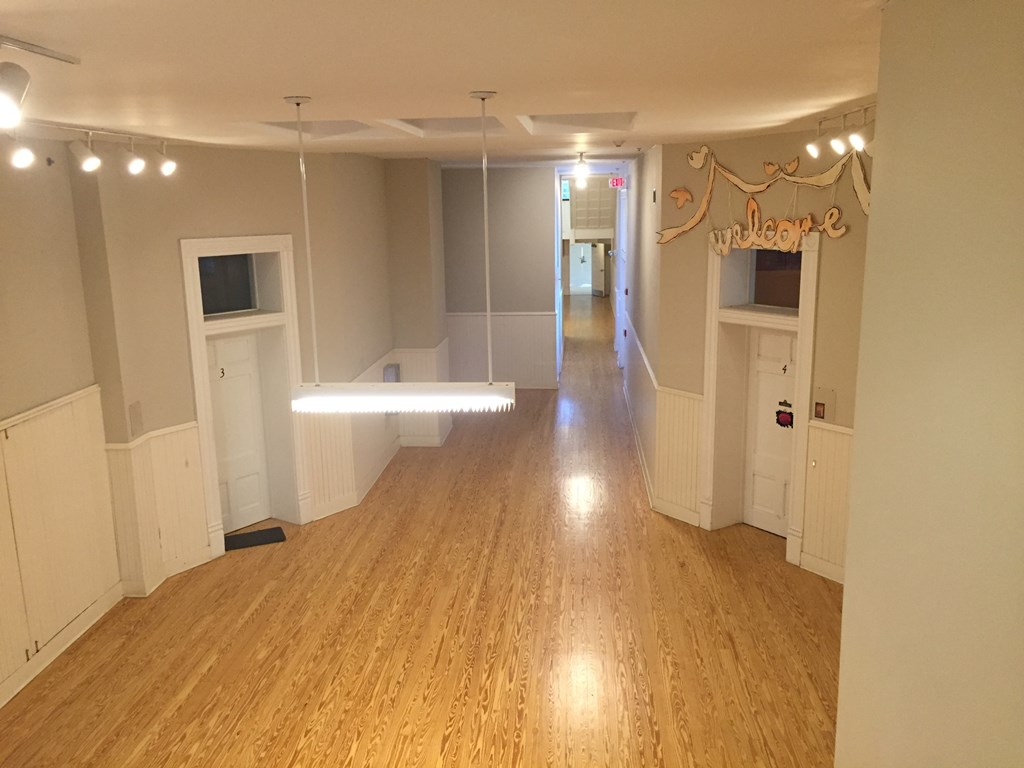 an empty living room with wood floors and white walls