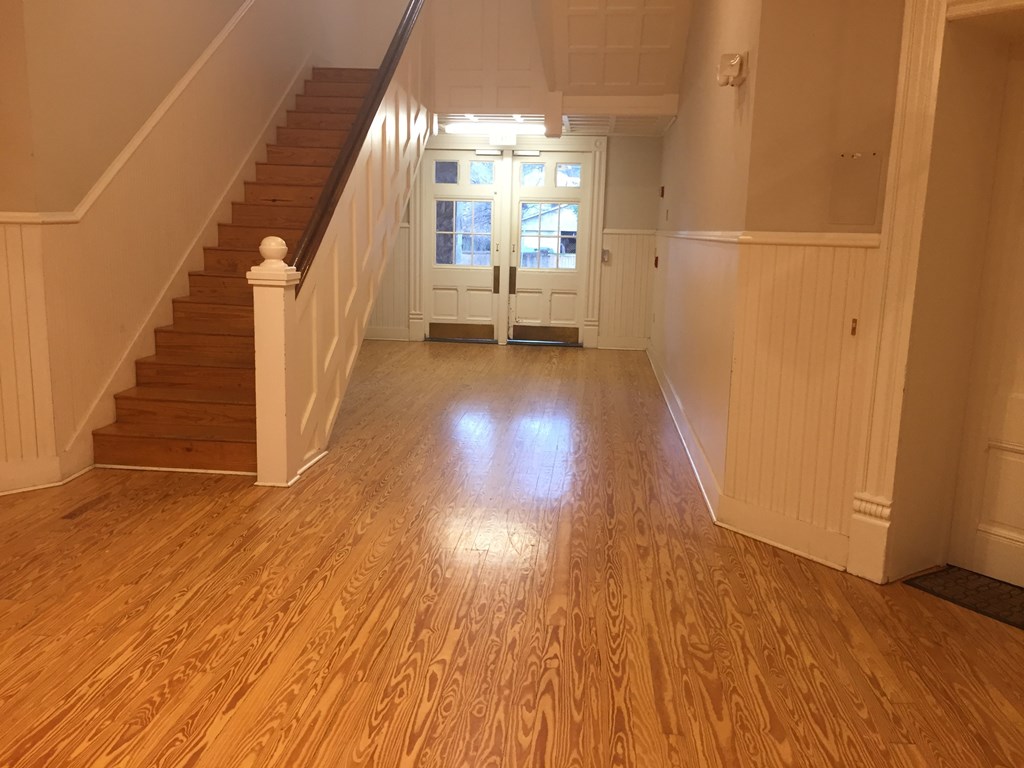 a living room with a hard wood floor and a staircase