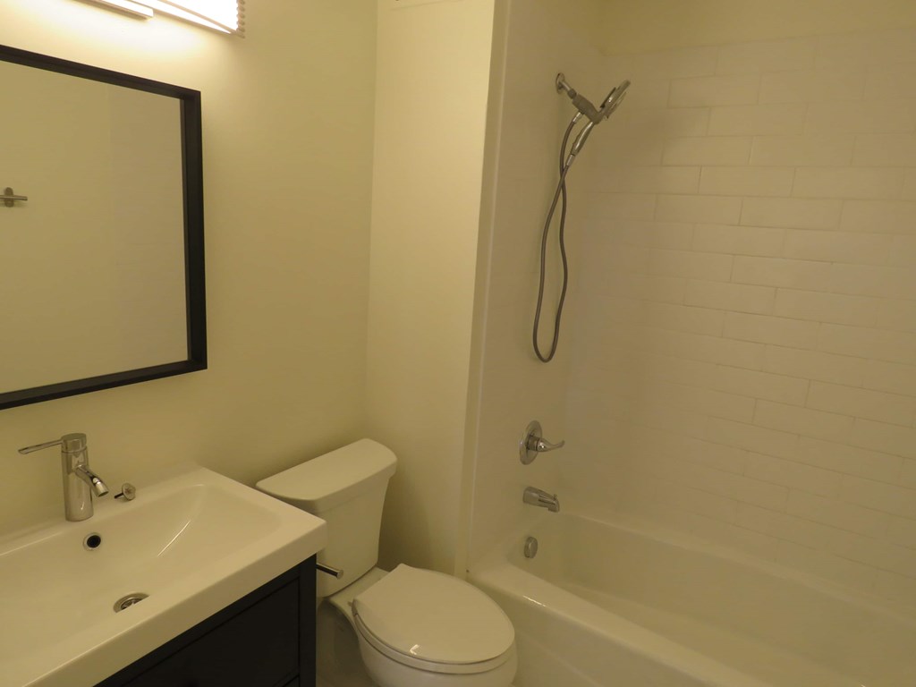 a bathroom with a toilet and a tub and a sink
