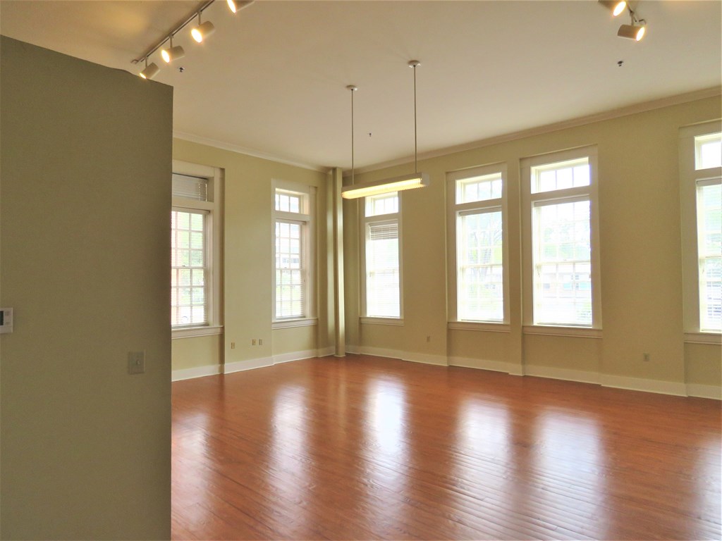 an empty living room with wood floors and windows