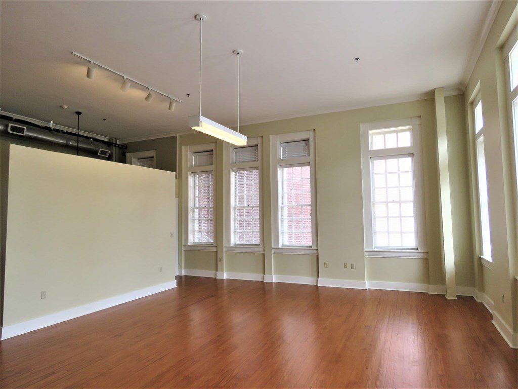 an empty living room with wood floors and windows