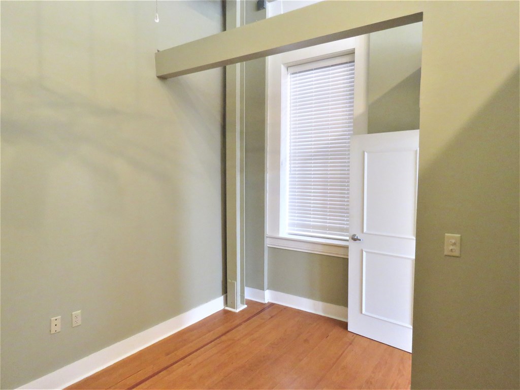 an empty room with a door to a closet and a window