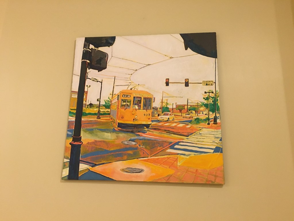 a painting of a yellow streetcar on a wall