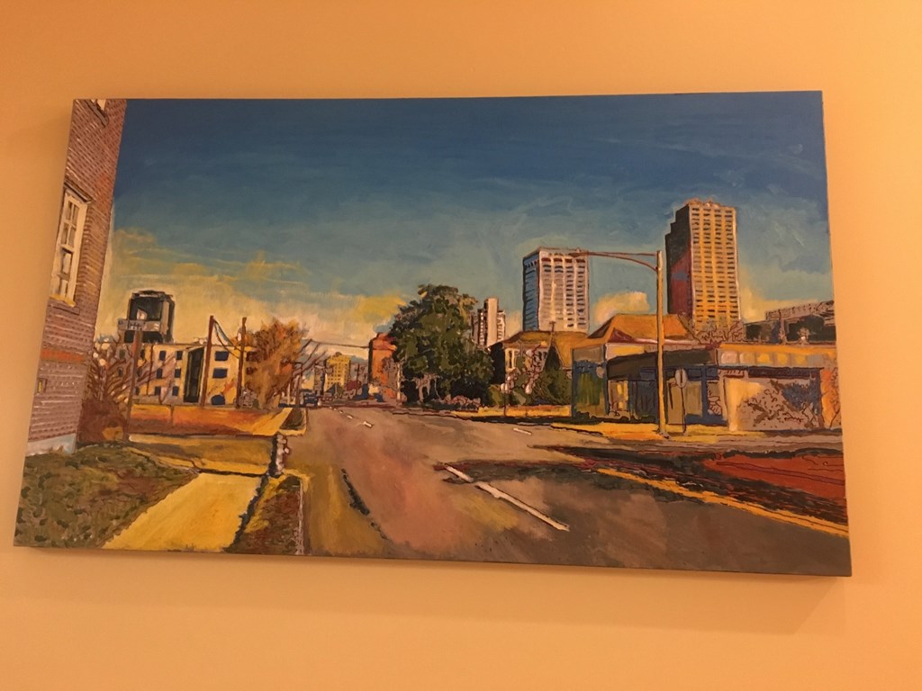 a painting of a street with a city in the background