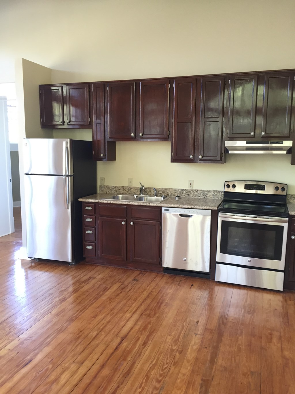 a kitchen with wooden floors and stainless steel appliances