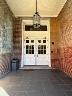 the front porch of a brick house with white doors