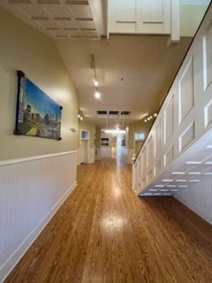 a hallway with a wood floor and a painting on the wall