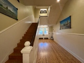 a long hallway with stairs and a painting on the wall