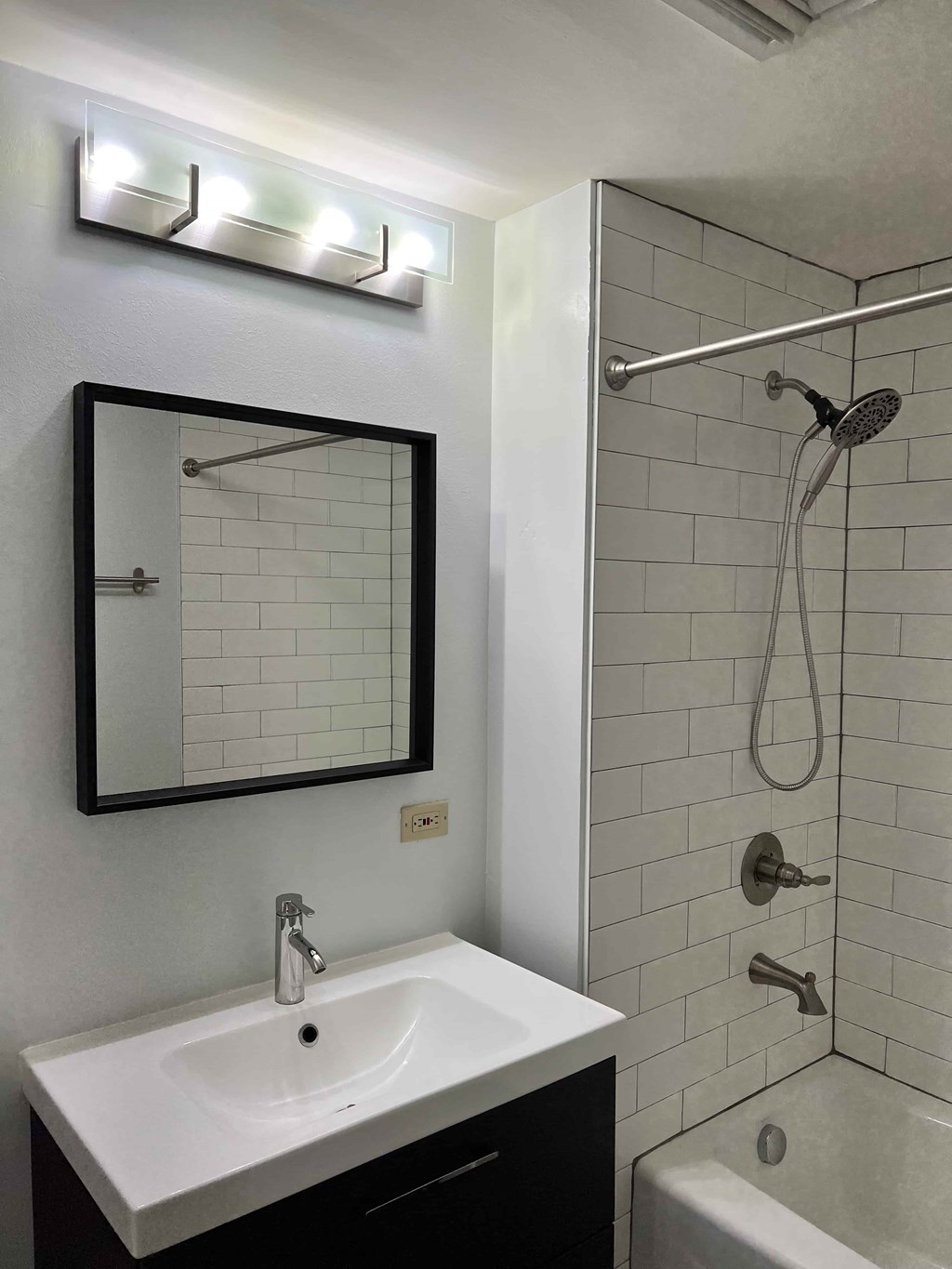 a bathroom with a sink and a mirror and a shower