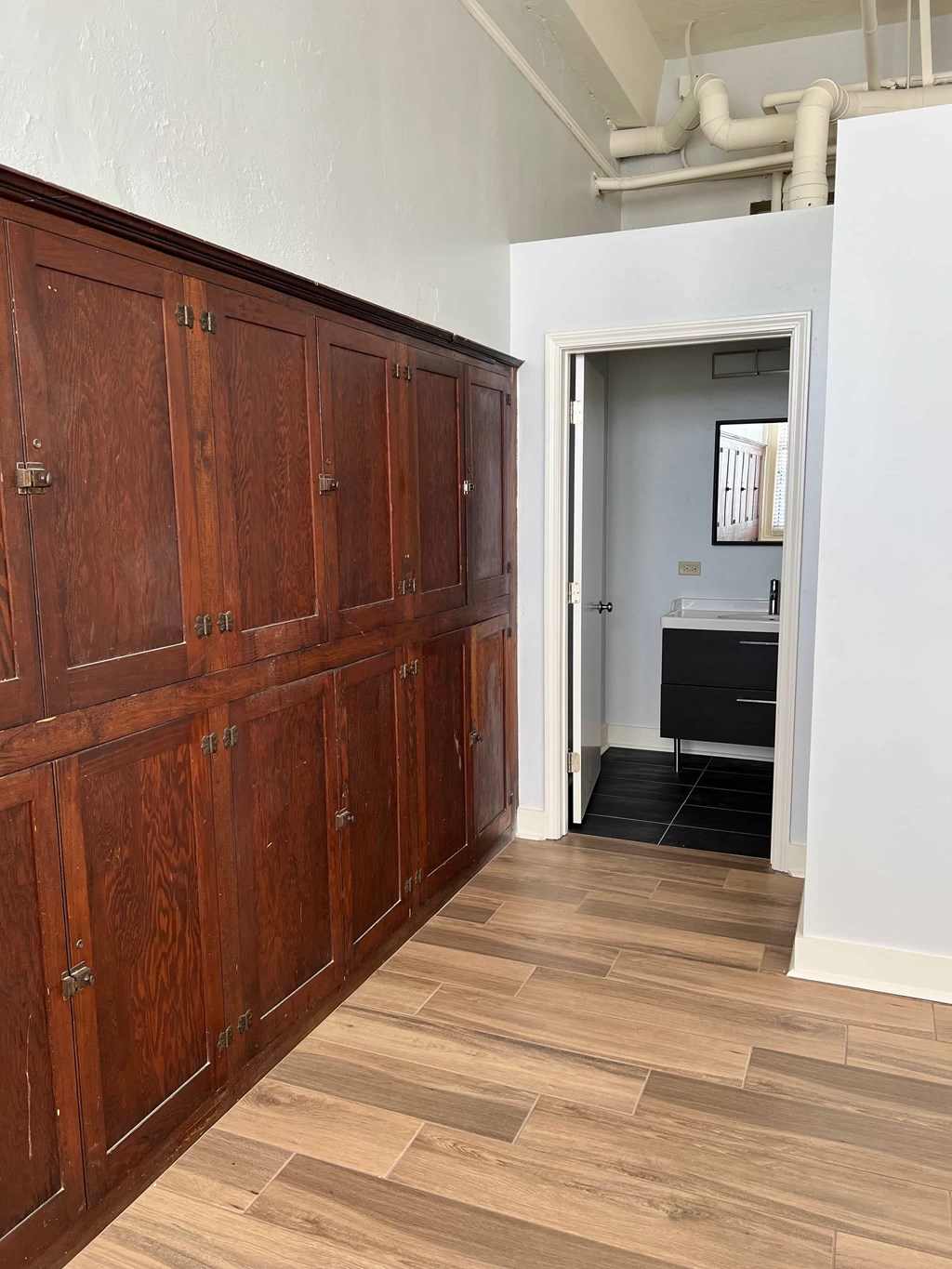 a long hallway with wood flooring and wooden cabinets