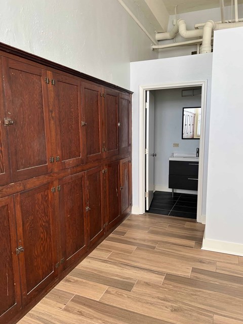 a long hallway with wood flooring and wooden cabinets