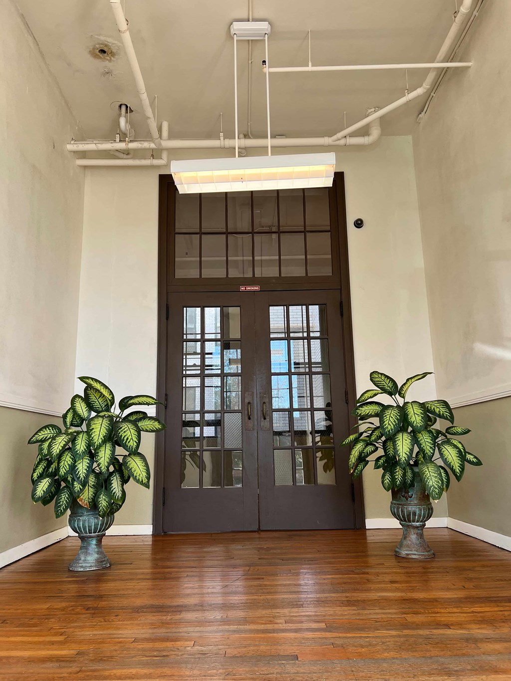 the lobby of a building with two potted plants