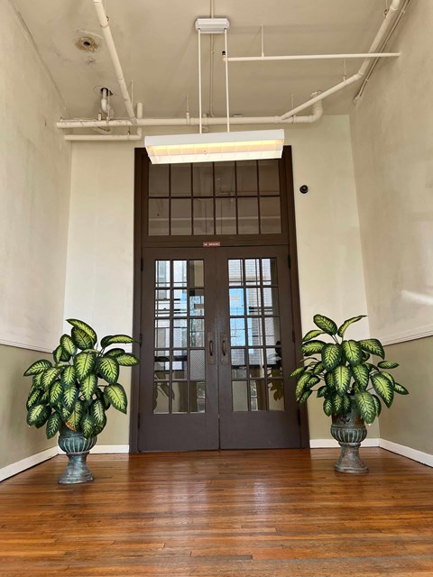 the lobby of a building with two potted plants