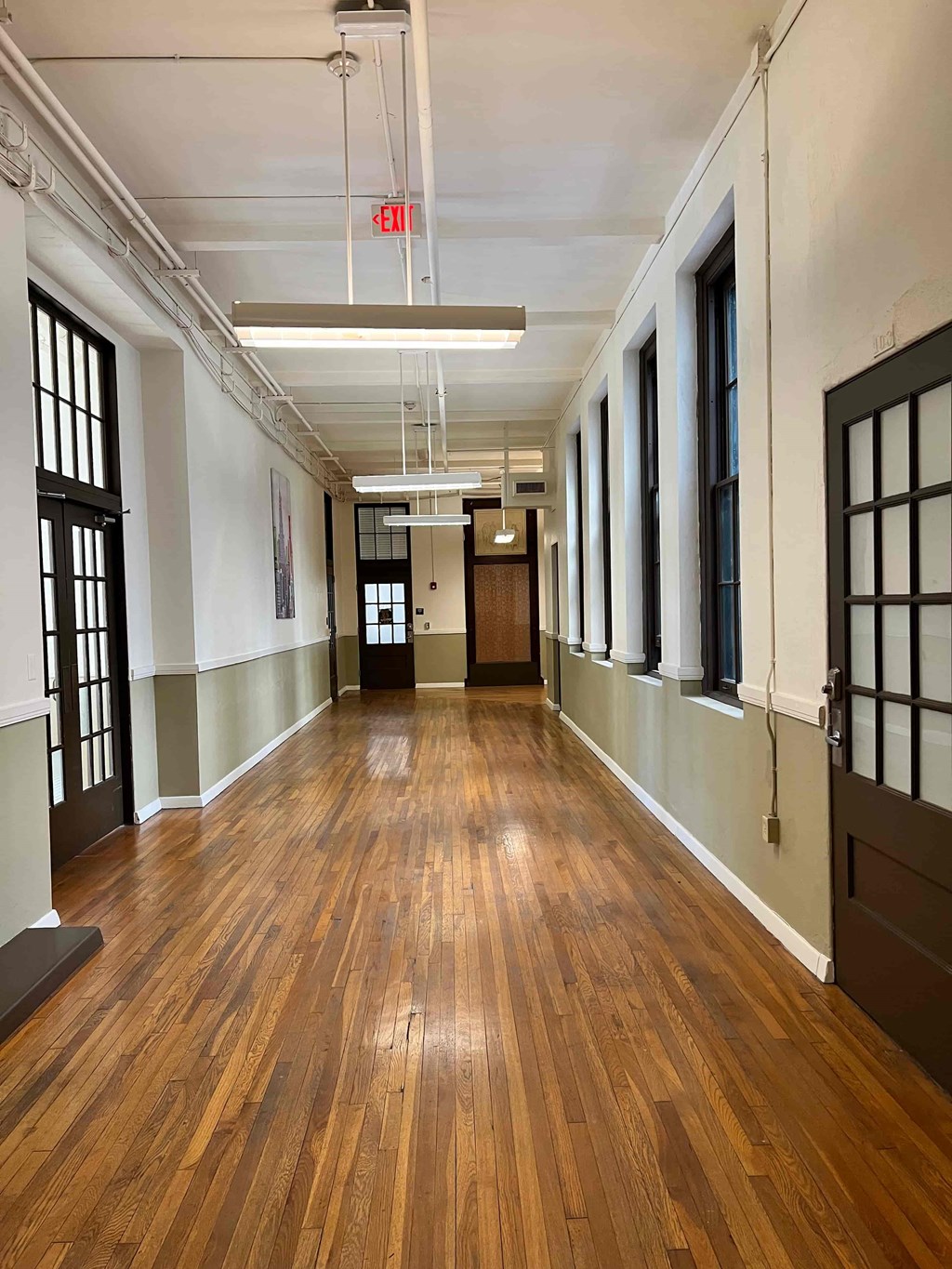 a large empty room with wood floors and a door