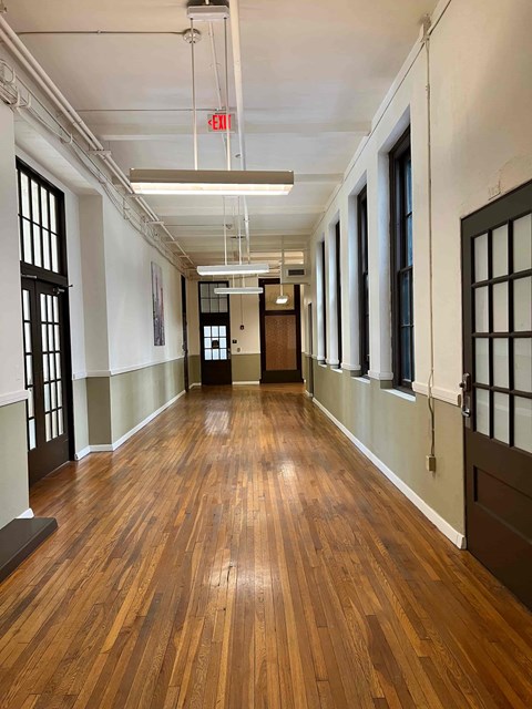 a large empty room with wood floors and a door