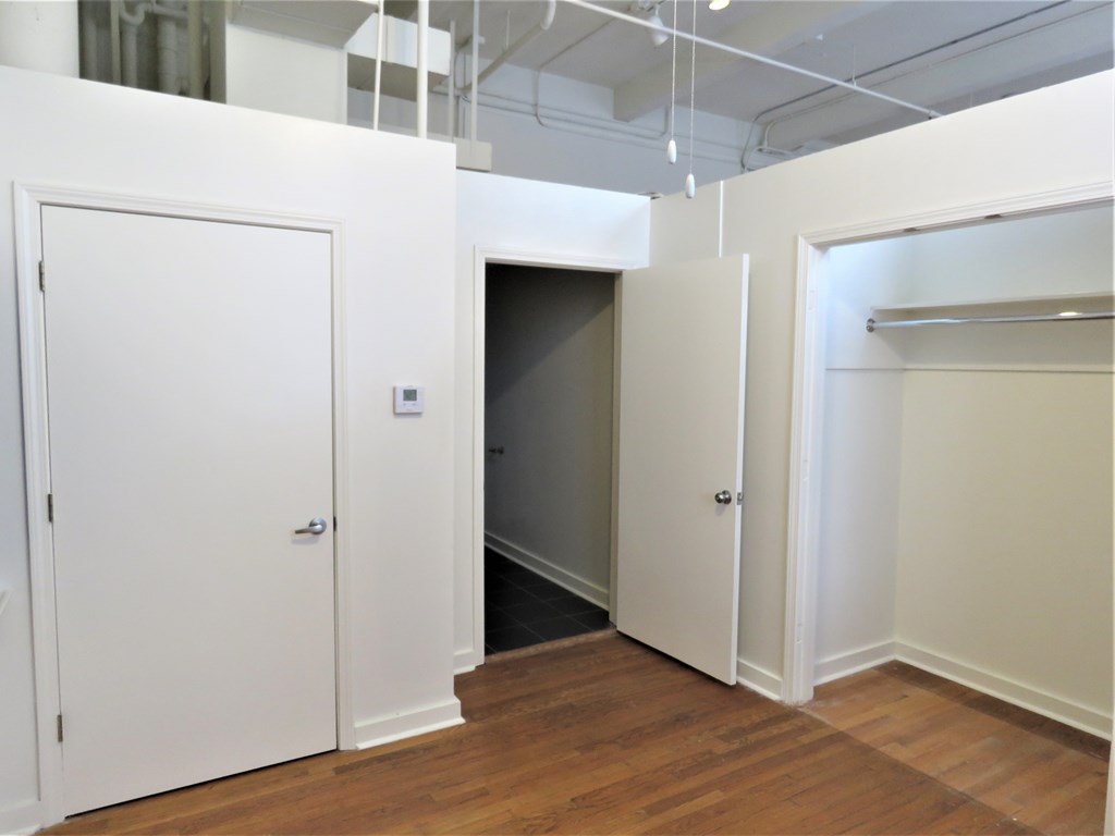 an empty room with white doors and a closet