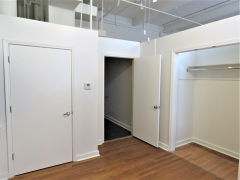 an empty room with white doors and a closet