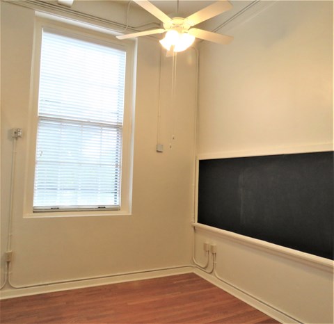 a living room with a ceiling fan and a tv