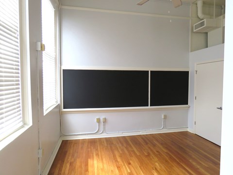 an empty classroom with a blackboard on the wall