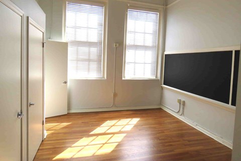 a room with a tv on the wall and a wood floor