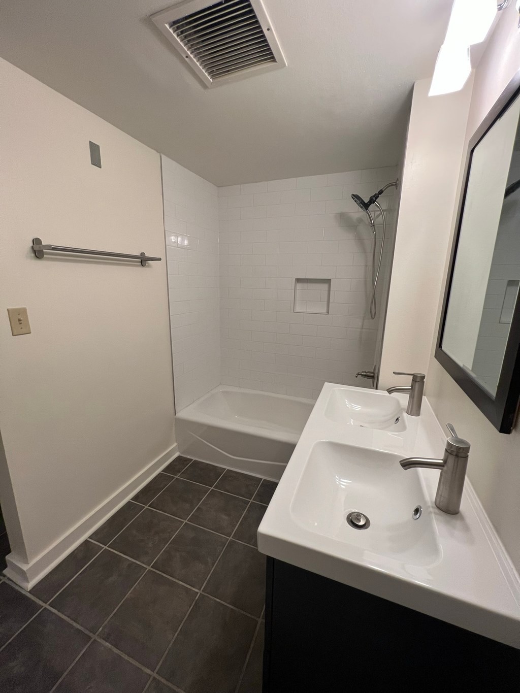 a bathroom with a sink and a shower and a mirror