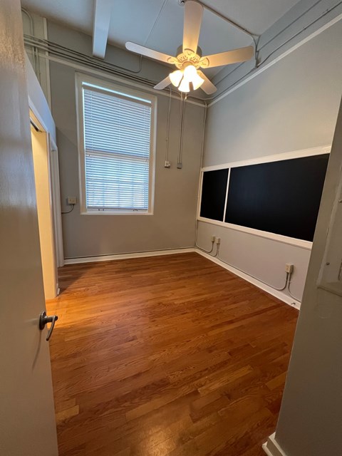 a living room with wood floors and a ceiling fan
