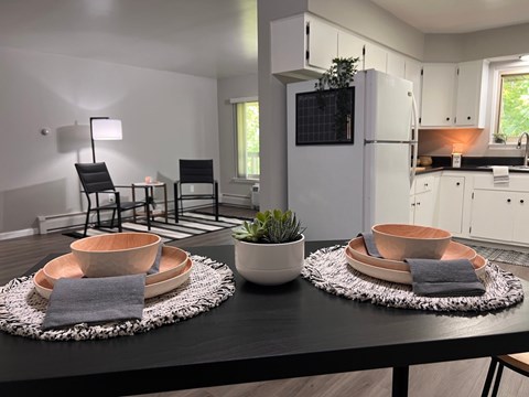 A modern kitchen with a black table and copper bowls on it.