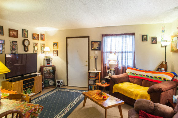 a living room with a yellow couch and a television