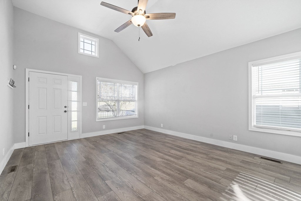 the living room of an empty house with a ceiling fan