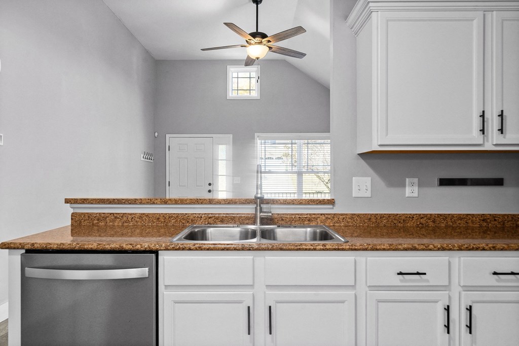 a kitchen with white cabinets and a granite counter top