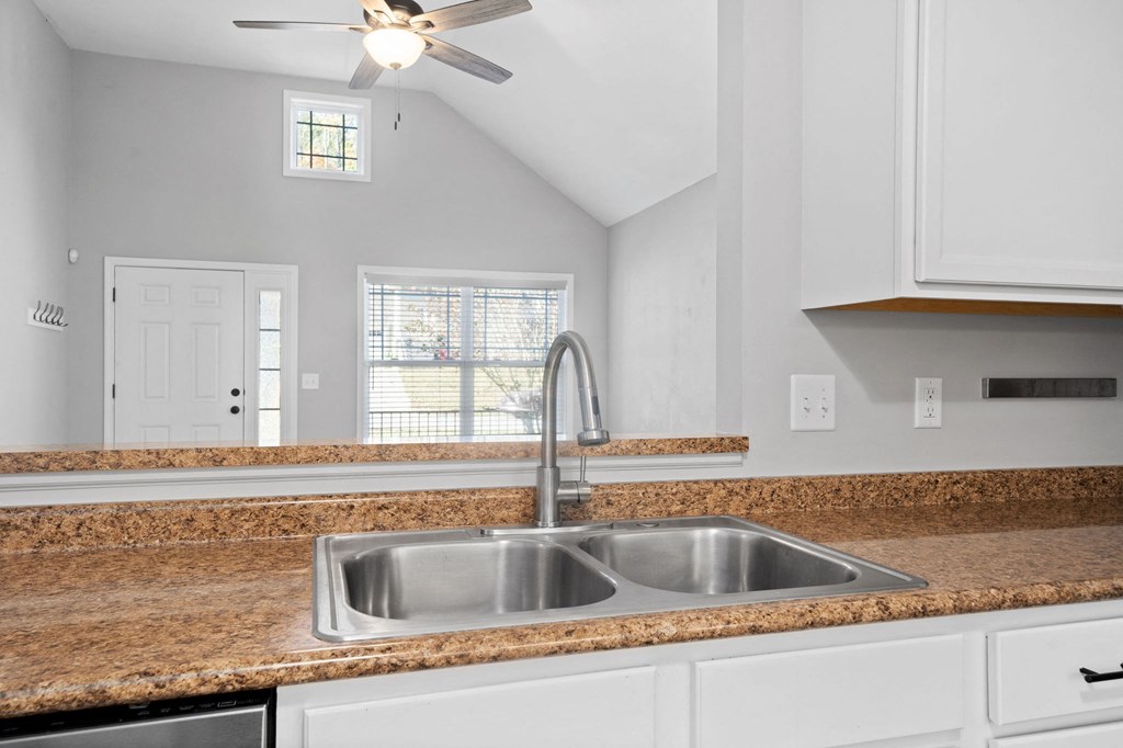 the kitchen has granite counter tops and a stainless steel sink