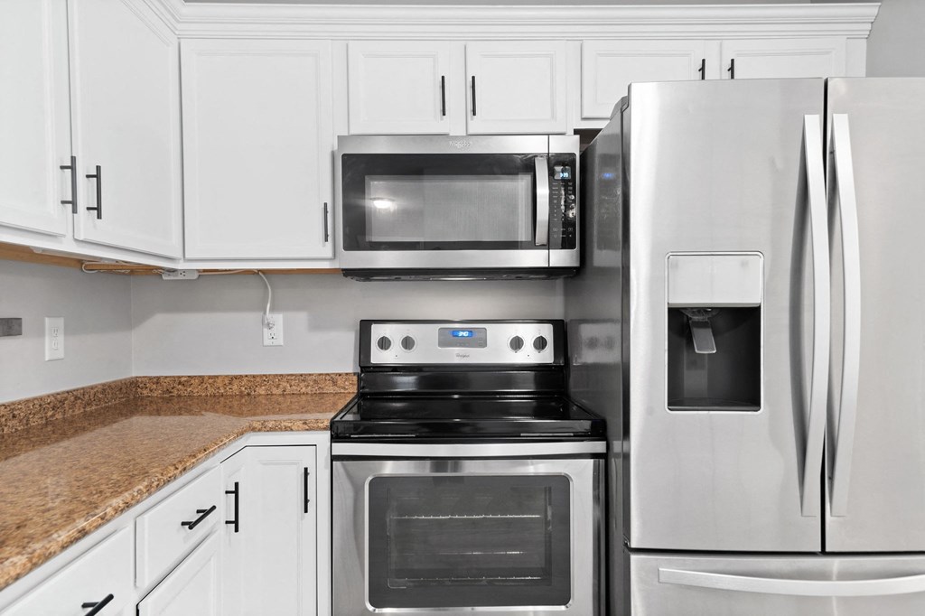 a kitchen with stainless steel appliances and white cabinets