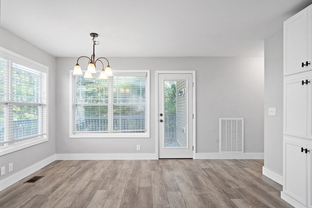 the living room and dining room in a new home with white walls and wood floors