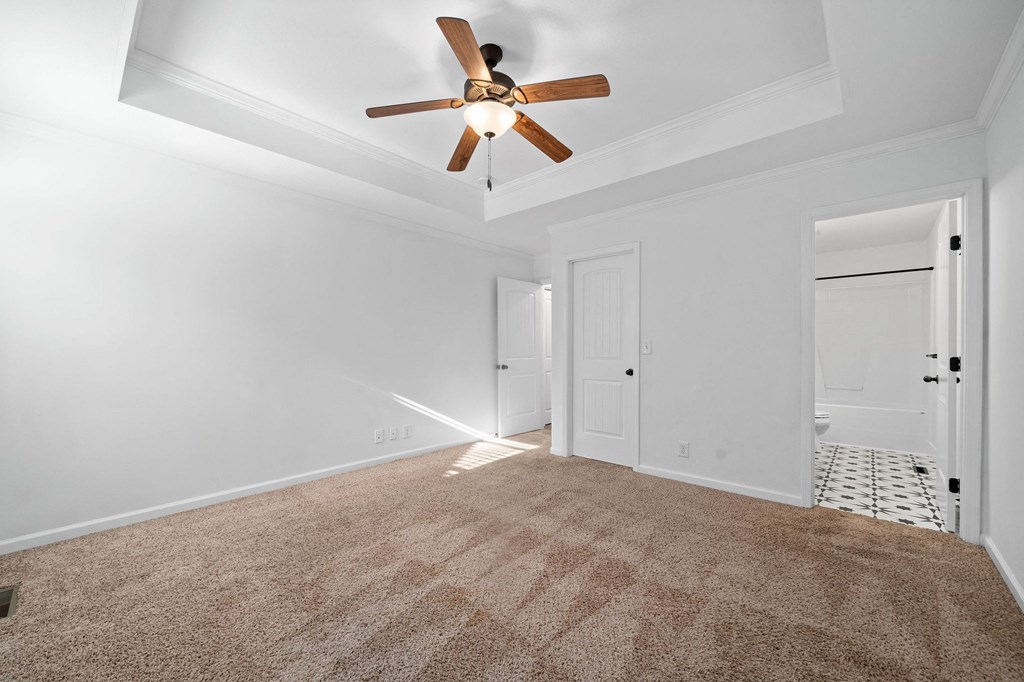 a living room with white walls and a ceiling fan