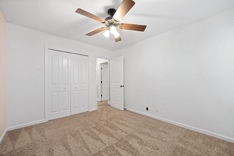a living room with carpet and a ceiling fan