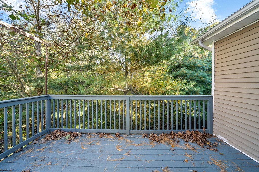 a deck with a view of trees and a house