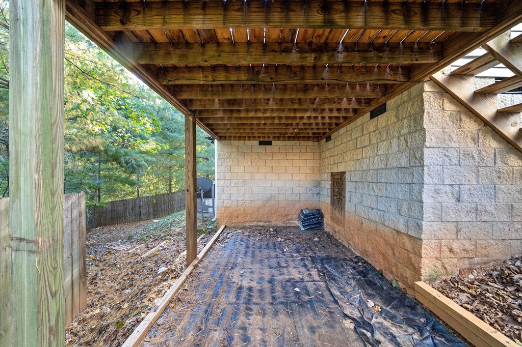 a back porch with a brick wall and a wooden roof