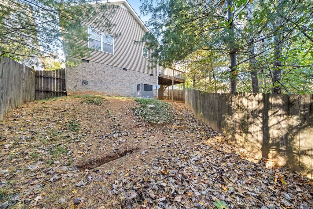 a backyard with a fence and a house with trees