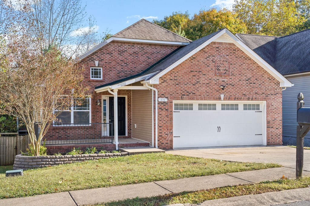 a small brick house with a white garage door
